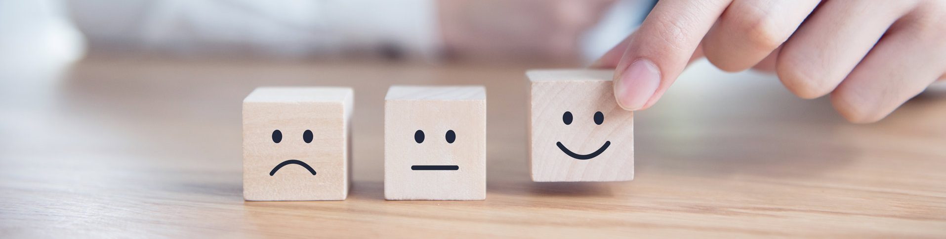 A man wearing a tie places three white blocks representing emotions