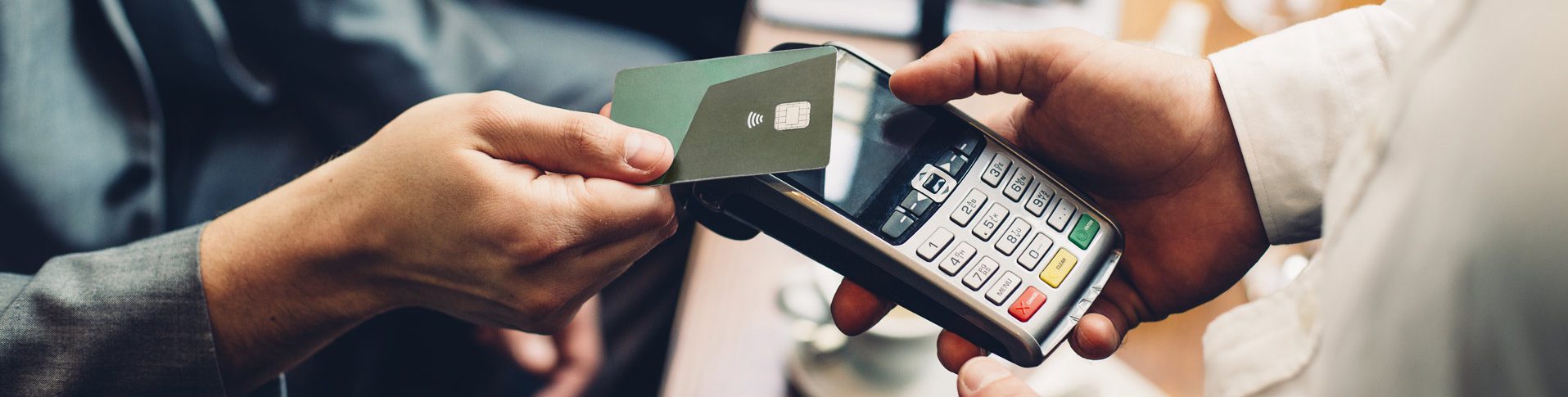 A man produces his credit card at a terminal