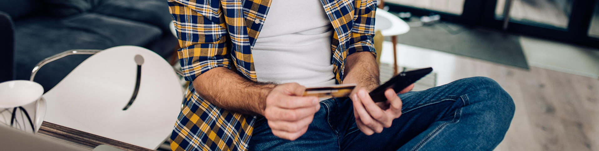 Homme assied avec sa carte de crédit effectuant un paiement en différé